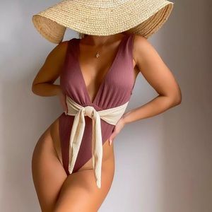 One piece swimsuit with adjustable bow that grabs your waist.